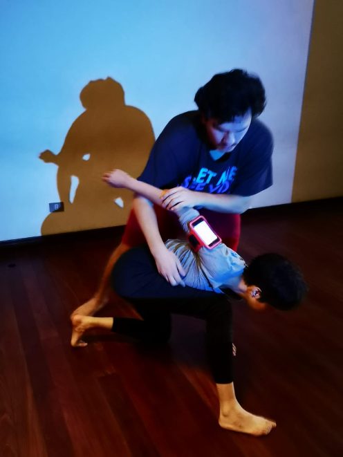 Participants of the OnChange() Lab moving together while holding lit smartphones.